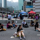 A woman takes her lunch while sitting on a highway, part of an area blocked off by protesters of the Occupy Central movement, in Hong Kong October 7, 2014. Pro-democracy demonstrations in Hong Kong rolled into early Tuesday with hundreds of students remaining camped out in the heart of the city after more than a week of rallies and behind-the-scenes talks showing modest signs of progress. REUTERS/Tyrone Siu (CHINA - Tags: POLITICS CIVIL UNREST FOOD) - RTR497NO